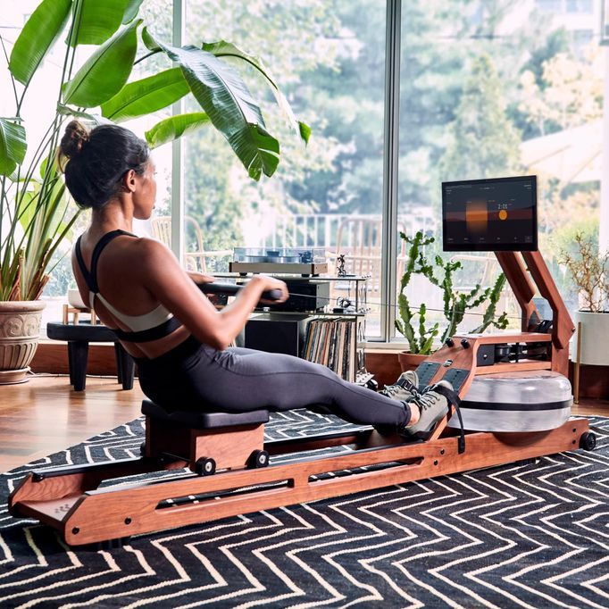 Woman using ergatta rower at home