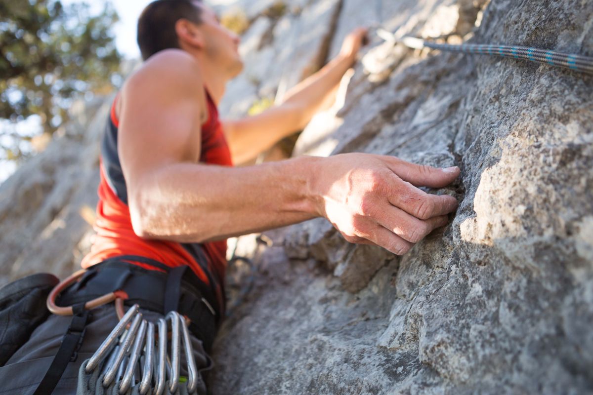 Climber in red t shirt climbs a gray rock a stron 2023 11 27 05 20 59 utc